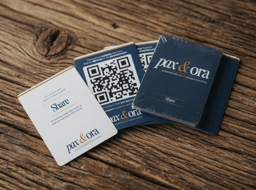 Catholic Prayer Cards — Pax & Ora Share Pack featuring navy and white cards with QR codes on a rustic wooden surface.