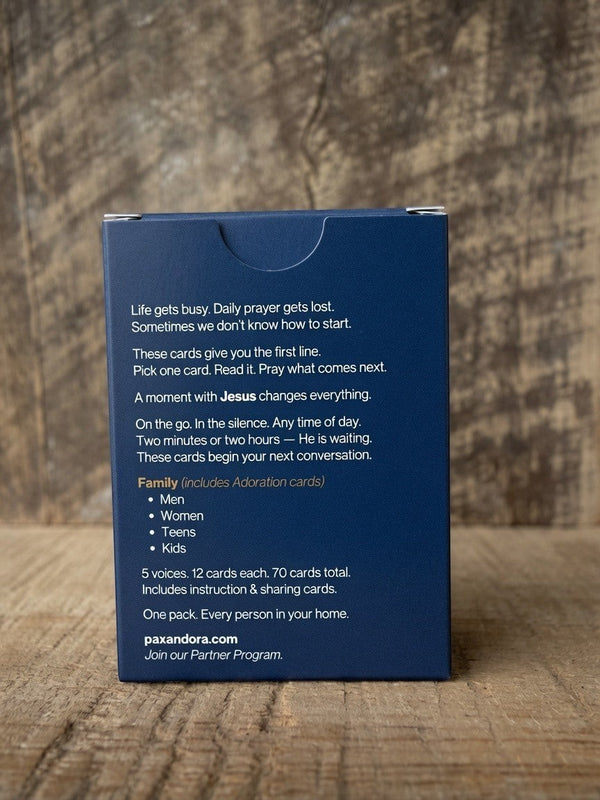 Catholic Prayer Cards — Pax & Ora family prayer card deck in a navy blue tuck box on a rustic wooden surface.