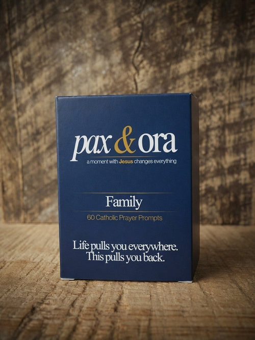 Catholic Prayer Cards — Pax & Ora Family Pack in a navy blue tuck box with white and gold text on a wooden surface.