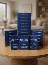 Catholic Prayer Cards — Pax & Ora prayer card packs stacked on a wooden table for outreach and spiritual reflection.