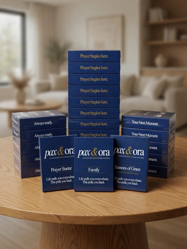 Catholic Prayer Cards — Pax & Ora prayer card packs stacked on a wooden table for outreach and spiritual reflection.