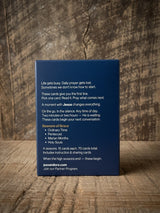 Catholic Prayer Cards — Pax & Ora Seasons of Grace deck in a navy blue box with white text on a rustic wood surface.