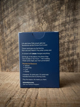 Catholic Prayer Cards — Pax & Ora The Sacred Seasons deck in a navy blue tuck box on a rustic wooden background.